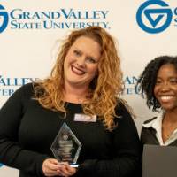 Two women holding awards